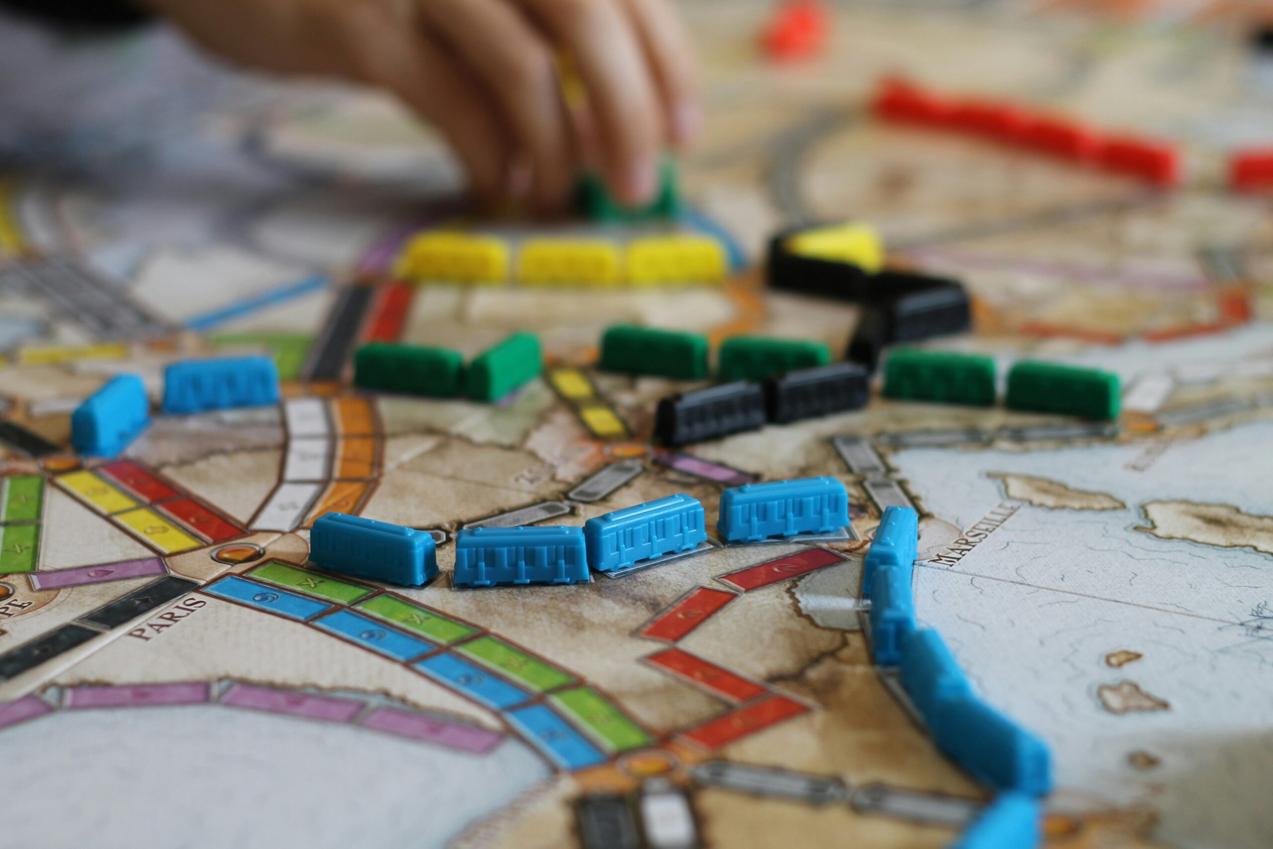 colored board game featuring game board with small train-like game pieces lined up